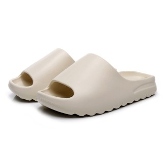 Muted white slide sandals with sleek design and slightly elevated heels, shown against a plain white backdrop.