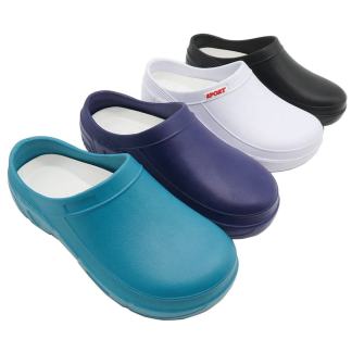 Four rubber clogs in teal, purple, white, and black, arranged in a staggered display on a white background.